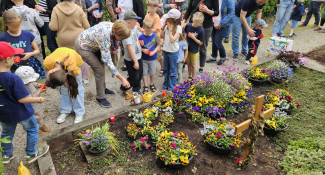 Die Kinder zünden Kerzen am Grab der Herz Jesu-Gemeinde an.