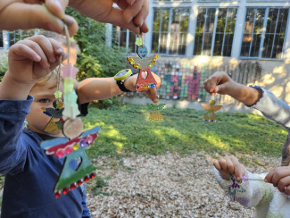 Kinder zeigen ihre selbstgestalteten Engel-Anhänger.